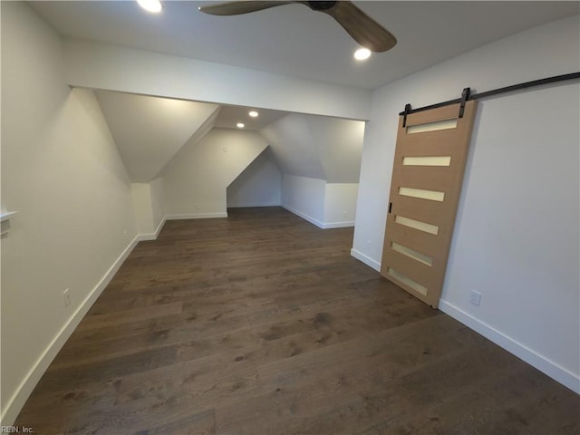 bonus room with a ceiling fan, wood finished floors, baseboards, recessed lighting, and a barn door