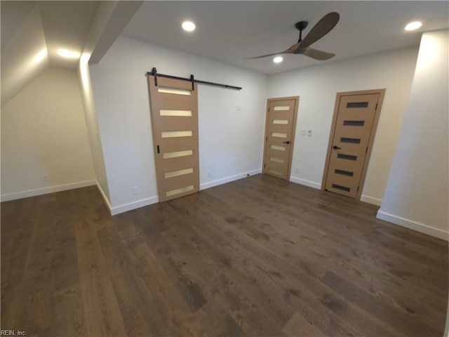 unfurnished bedroom with dark wood-style floors, recessed lighting, baseboards, and a barn door