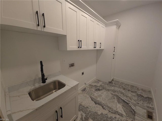 clothes washing area featuring baseboards, hookup for an electric dryer, cabinet space, a sink, and washer hookup