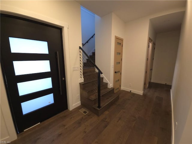 foyer featuring stairway, baseboards, dark wood-type flooring, and visible vents