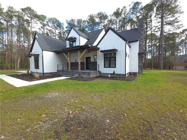 modern inspired farmhouse with board and batten siding, a chimney, a front yard, and roof with shingles