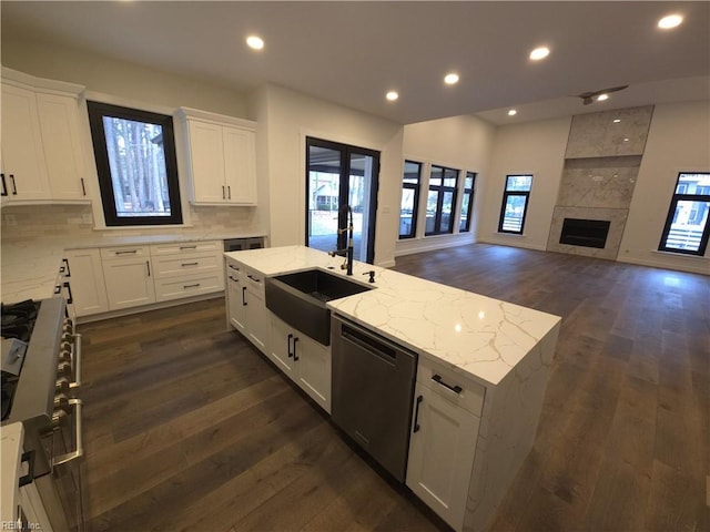 kitchen with recessed lighting, dark wood-style flooring, a tile fireplace, decorative backsplash, and appliances with stainless steel finishes