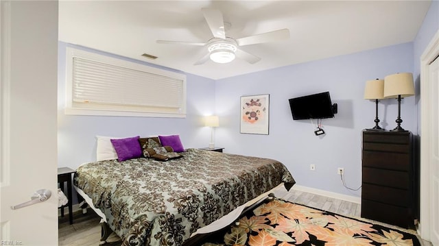 bedroom with visible vents, baseboards, a ceiling fan, and wood finished floors