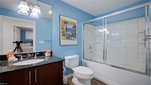 bathroom featuring a chandelier, toilet, tile patterned floors, combined bath / shower with glass door, and vanity