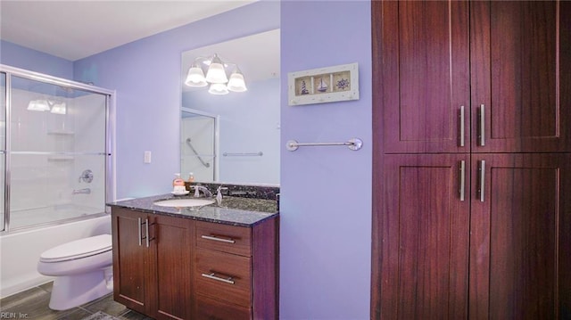 bathroom with enclosed tub / shower combo, toilet, and vanity