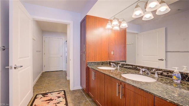 full bathroom with double vanity, baseboards, and a sink