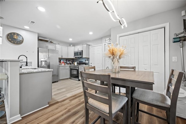 dining space featuring recessed lighting, light wood-style floors, and visible vents