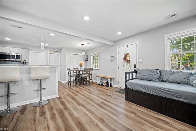 living room with visible vents, a healthy amount of sunlight, and light wood-type flooring