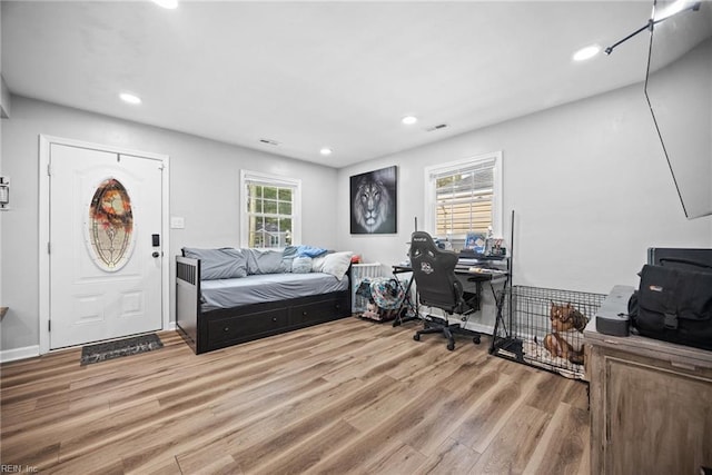 bedroom with light wood finished floors, visible vents, recessed lighting, and baseboards