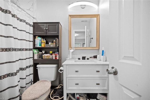 full bathroom with curtained shower, toilet, visible vents, and vanity