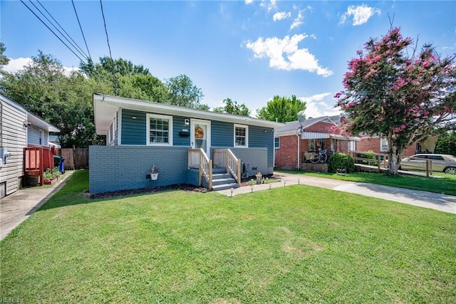 view of front of property with brick siding, concrete driveway, a front yard, and fence