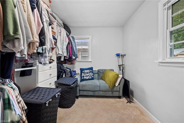 walk in closet featuring light colored carpet