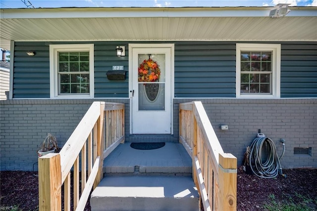 property entrance featuring crawl space and brick siding