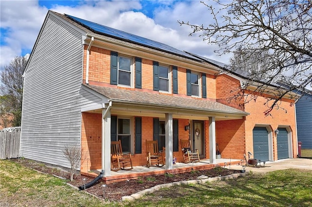 traditional-style house featuring brick siding, a porch, concrete driveway, and fence