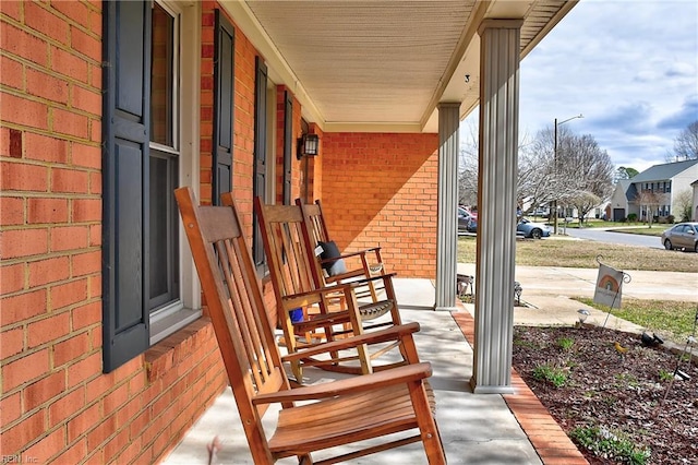 wooden deck with a residential view and covered porch