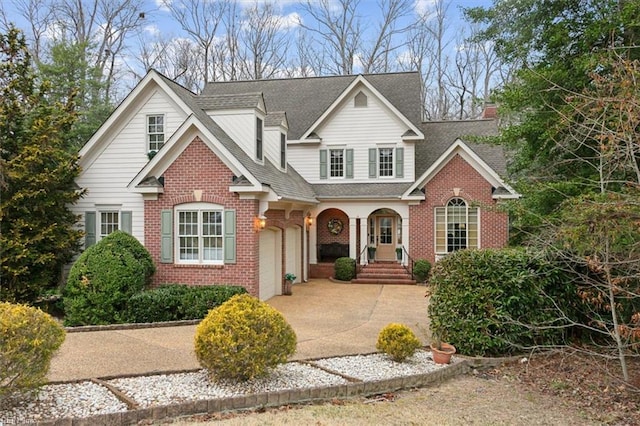 traditional home featuring brick siding, concrete driveway, a garage, and roof with shingles