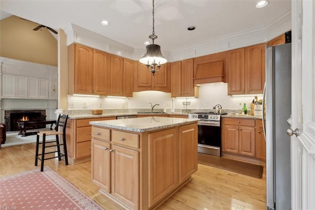 kitchen with a sink, custom range hood, light wood-style flooring, and stainless steel appliances