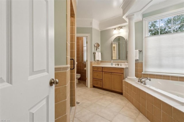 bathroom with toilet, decorative columns, vanity, and ornamental molding