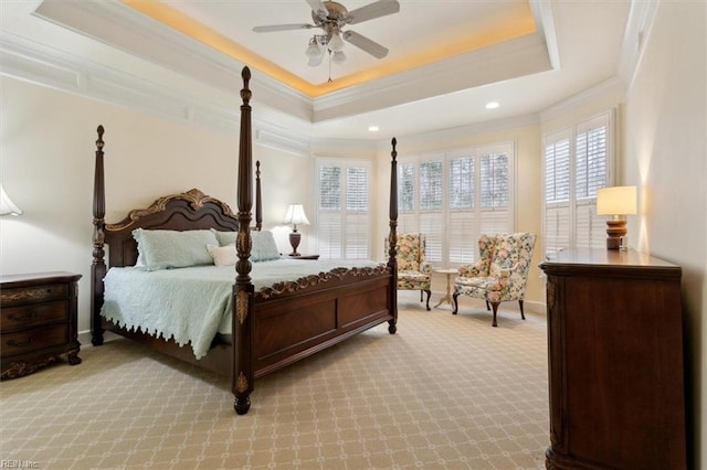 carpeted bedroom featuring a ceiling fan, a tray ceiling, and crown molding