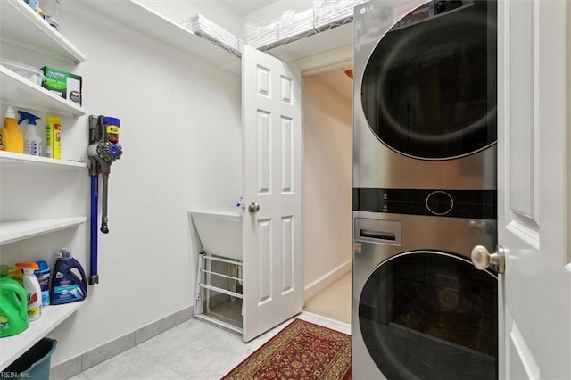 washroom featuring laundry area, stacked washer / drying machine, and baseboards