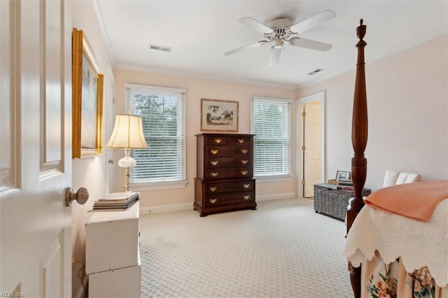 carpeted bedroom featuring visible vents, a ceiling fan, crown molding, and baseboards