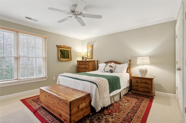 bedroom with visible vents, crown molding, baseboards, carpet floors, and a ceiling fan