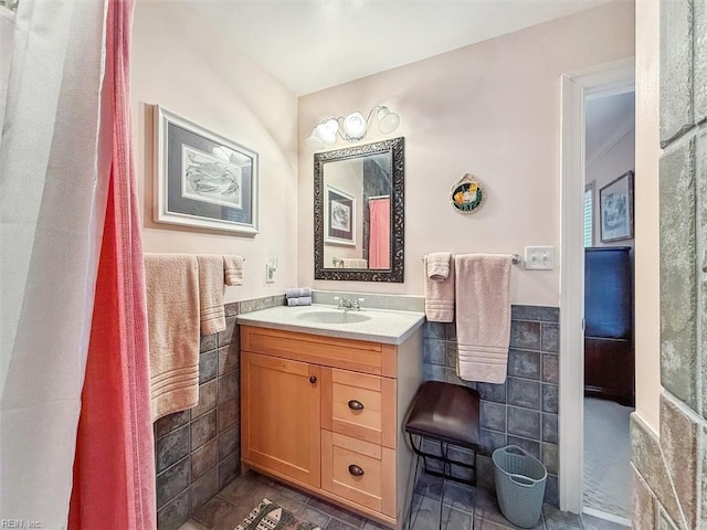 bathroom with vanity and tile walls