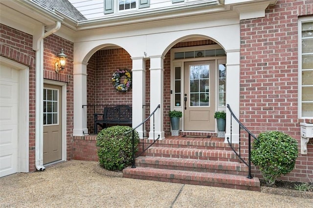 entrance to property with brick siding, covered porch, an attached garage, and a shingled roof