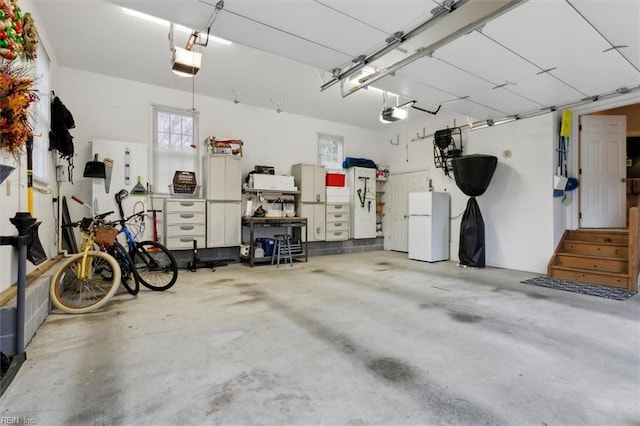 garage featuring a garage door opener and freestanding refrigerator