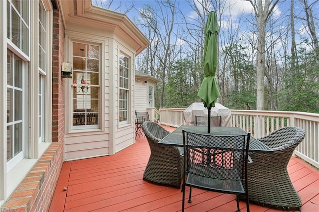 wooden deck featuring area for grilling and outdoor dining area