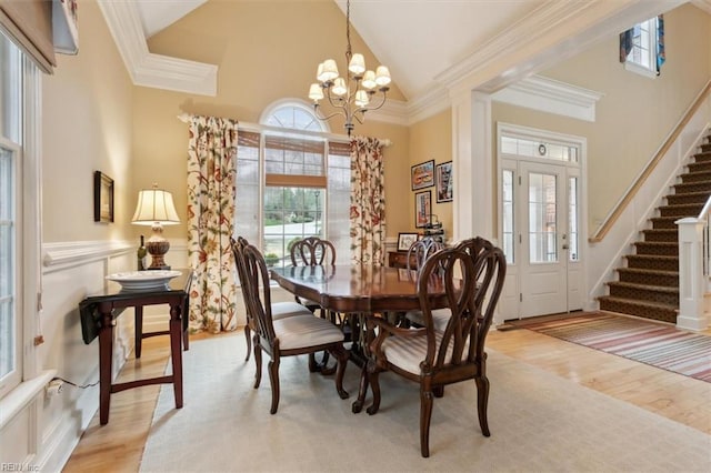 dining room featuring crown molding, stairway, and light wood-type flooring