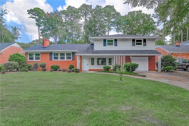 tri-level home with driveway, a chimney, a front lawn, a garage, and brick siding