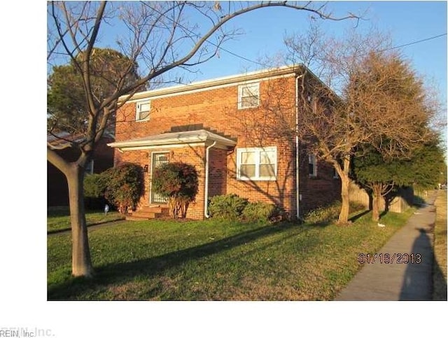 view of front of property featuring brick siding and a front yard