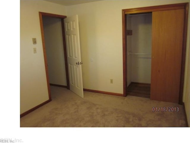 unfurnished bedroom featuring carpet flooring, baseboards, and a closet