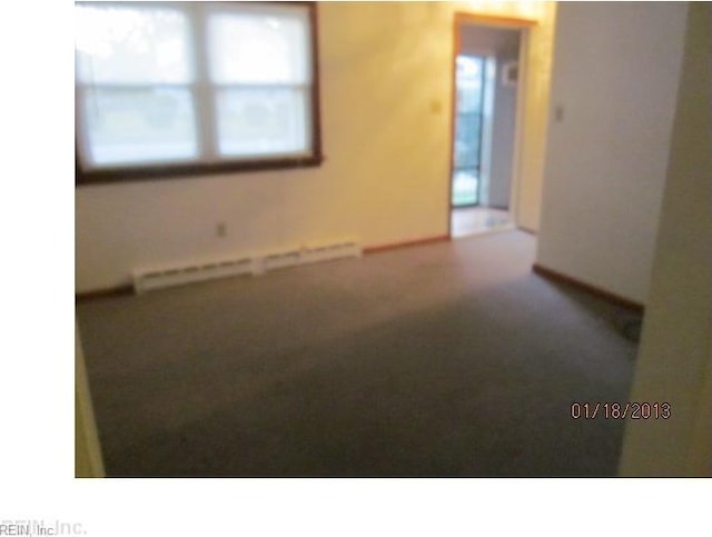 unfurnished room featuring a baseboard heating unit