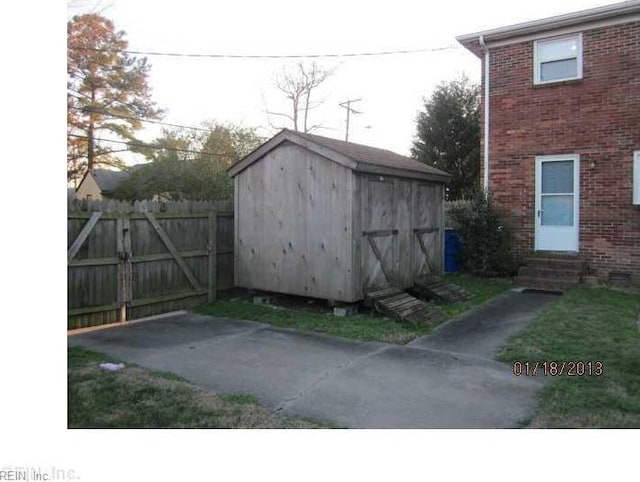 view of shed featuring a gate, entry steps, and fence