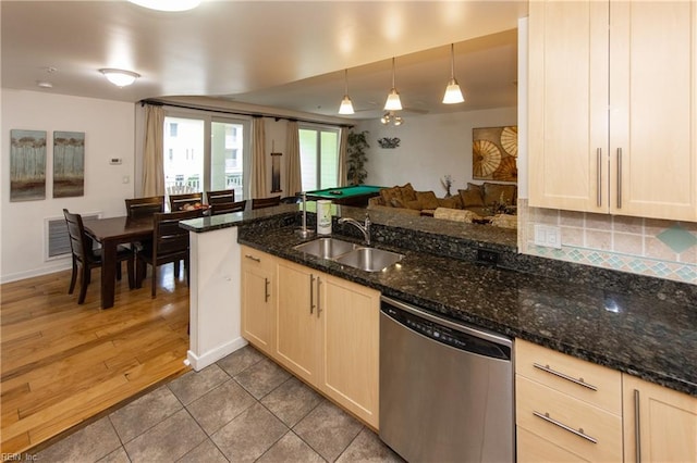 kitchen featuring visible vents, a sink, stainless steel dishwasher, dark stone counters, and decorative backsplash