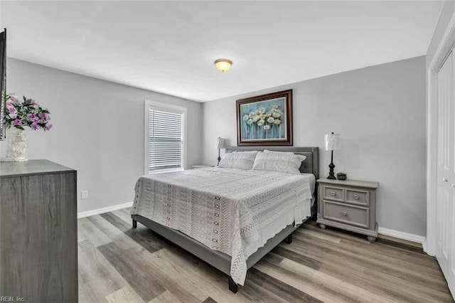 bedroom featuring a closet, baseboards, and wood finished floors