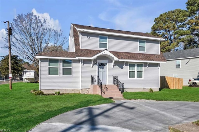 view of front of home featuring a shingled roof, a front yard, and fence