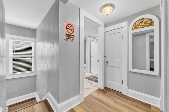 foyer entrance with wood finished floors and baseboards