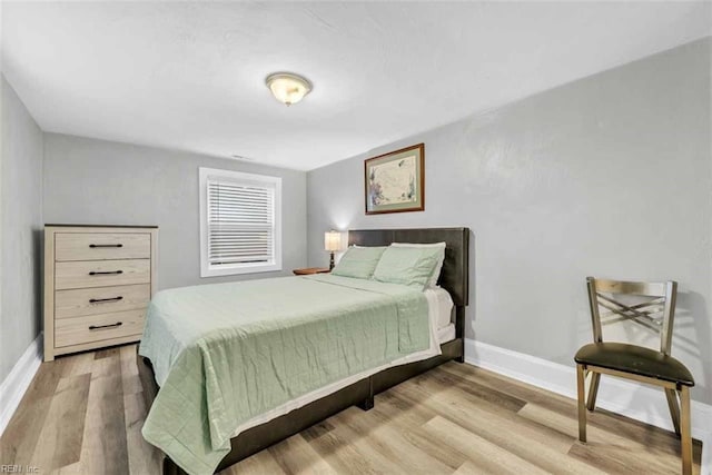 bedroom featuring baseboards and wood finished floors