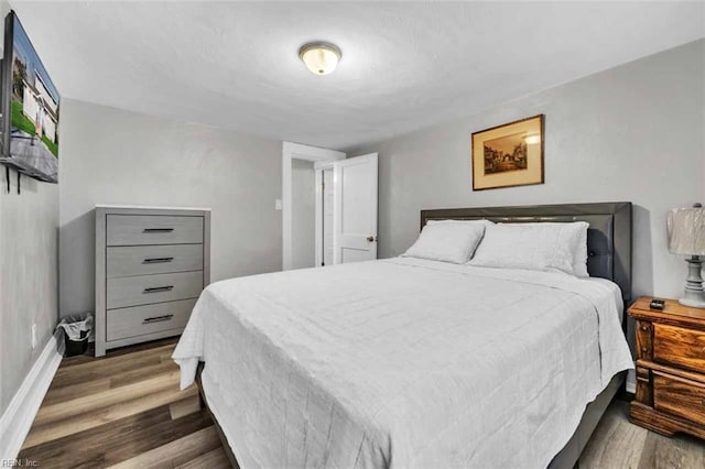 bedroom with wood finished floors and baseboards