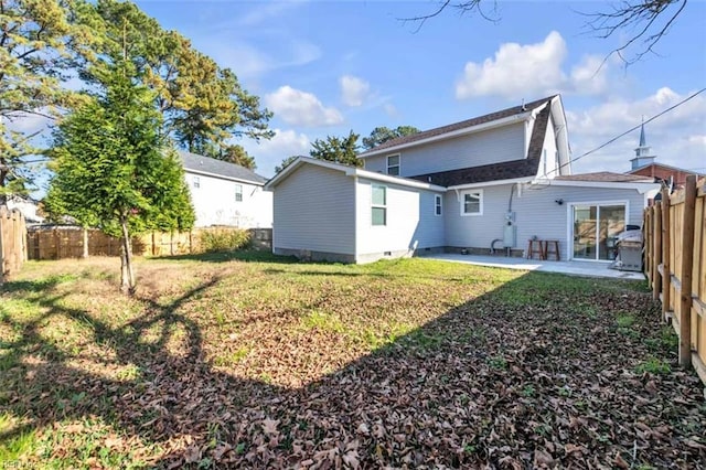 rear view of property featuring a lawn, a fenced backyard, and a patio area