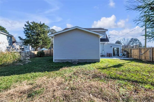 view of home's exterior featuring a patio, french doors, a lawn, and a fenced backyard