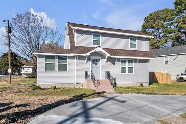 view of front of home with roof with shingles and fence