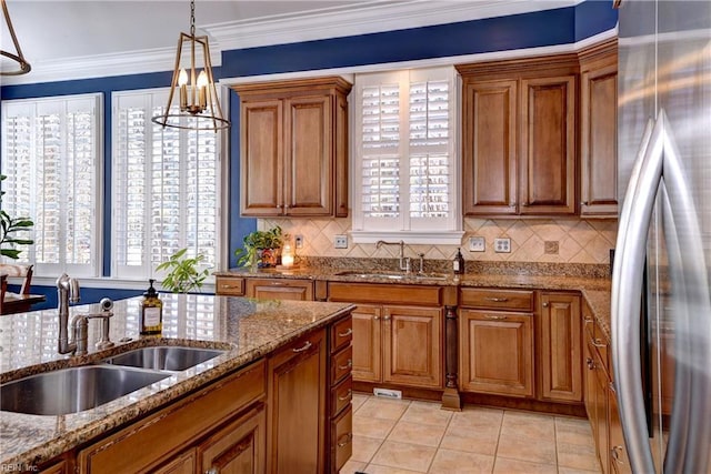 kitchen with a sink, stainless steel fridge, and brown cabinets