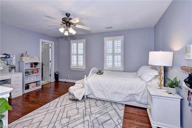 bedroom featuring visible vents, baseboards, a ceiling fan, and wood finished floors