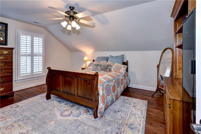 bedroom with visible vents, a ceiling fan, wood finished floors, baseboards, and vaulted ceiling