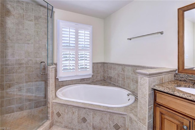 full bath with vanity, a garden tub, and a stall shower