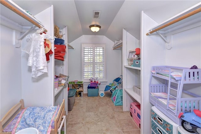 spacious closet with tile patterned floors, visible vents, and lofted ceiling